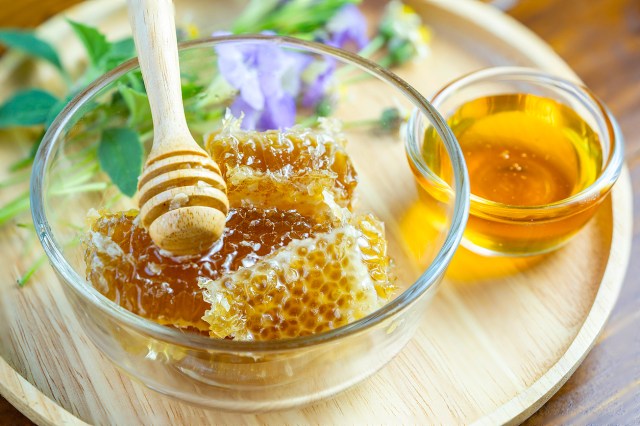 An image of a bowl of honeycomb and a small bowl of honey