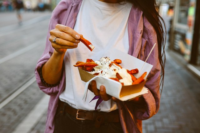 An image of a woman holding a plate of fries