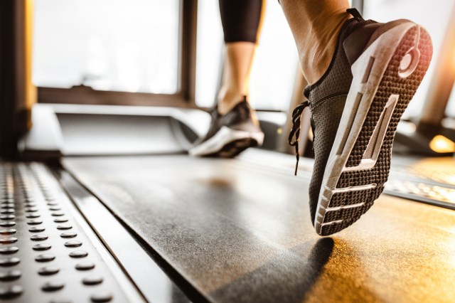 A close-up image of a feet walking on a treadmill