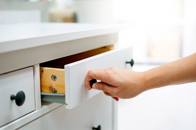 An image of a hand pulling a white drawer