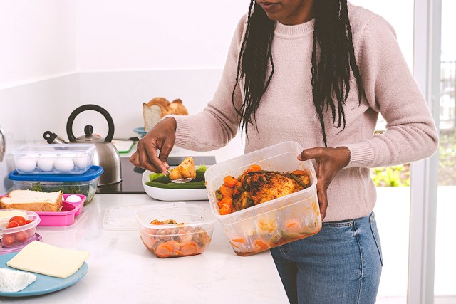 A woman packs items into a large plastic container