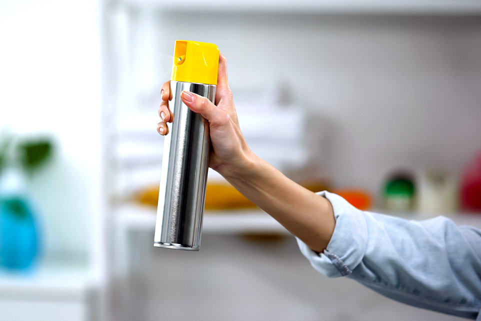 An image of a person holding a silver and yellow cleaning product