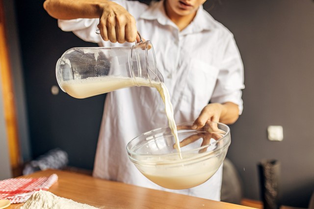 An image of person pouring a pitcher of milk into a bowl