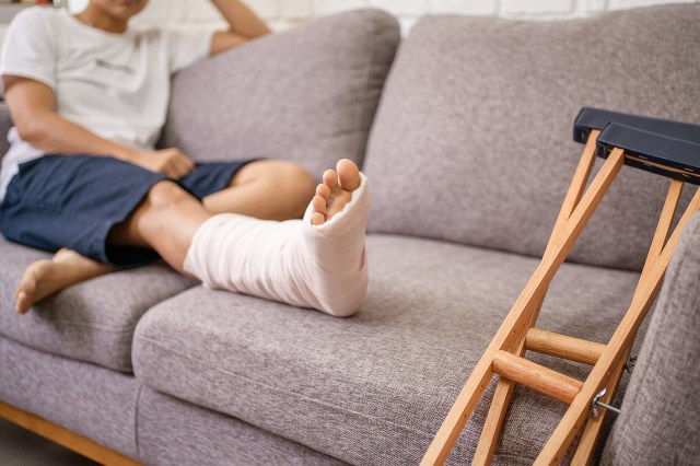 An image of a person with a cast on their foot sitting on the couch