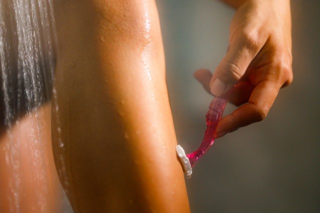 An image of a woman shaving her legs