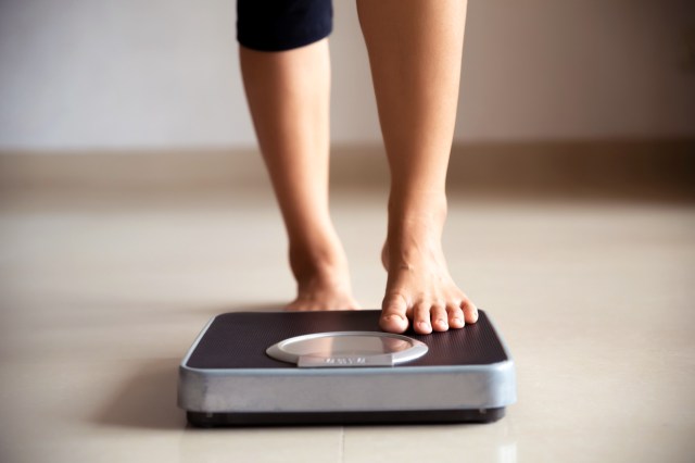 An image of a person stepping onto a scale