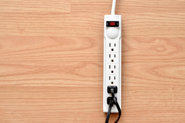 An image of a white power strip on a wood floor