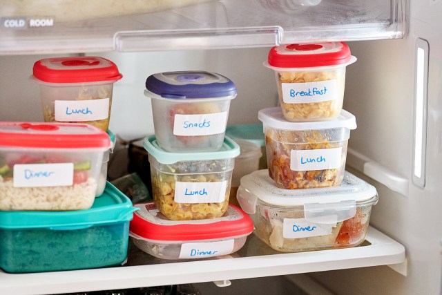 Labelled plastic containers stacked inside of a freezer
