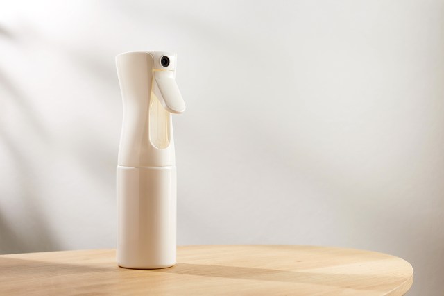 An image of a white spray bottle on a wooden table
