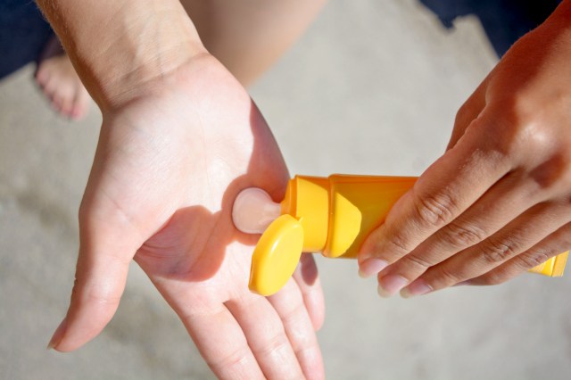 An image of a person squirting sunscreen onto their palm
