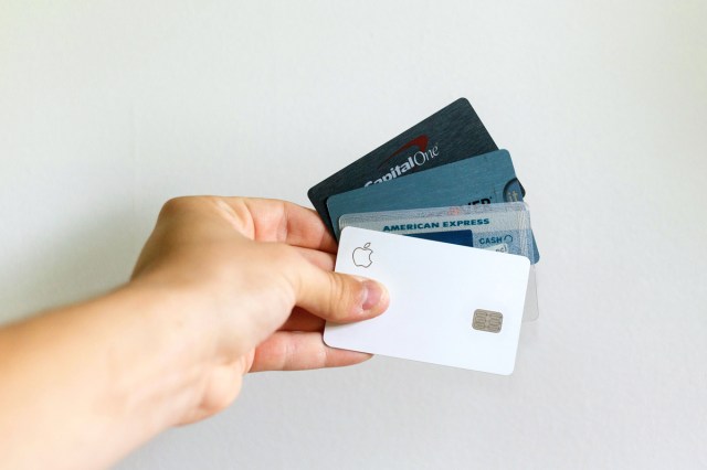 An image of a hand holding four credit cards