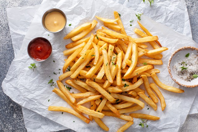 An image of French fries and dipping sauces on wax paper