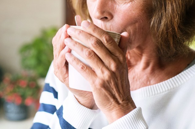 An image of an older woman drinking from a cup