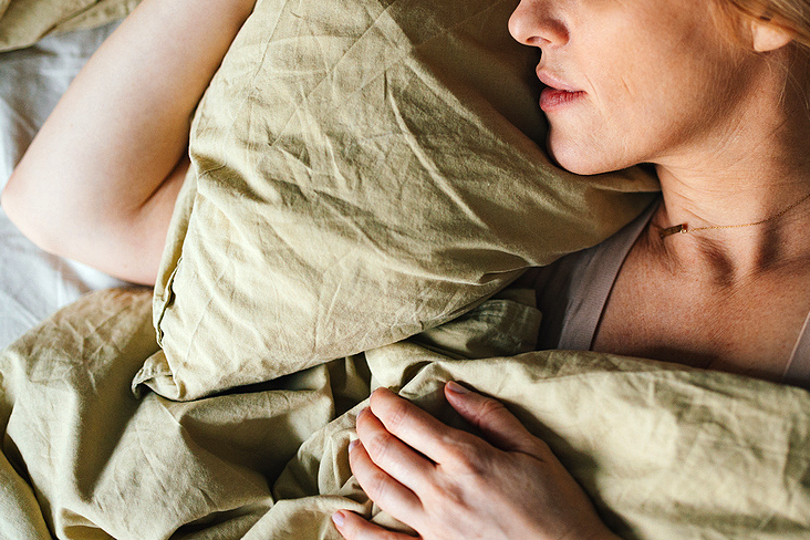 An image of a woman sleeping in bed