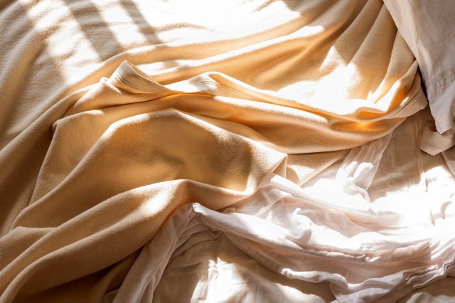 An image of an unmade bed with white sheets
