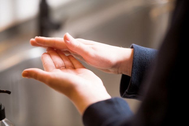 An image of a person rubbing their hands with sanitizer