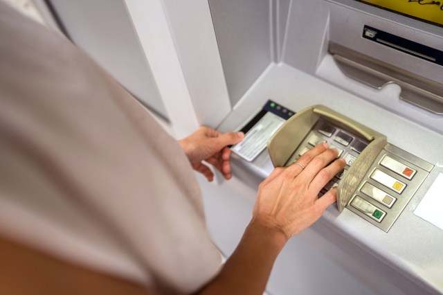An image of a woman using an ATM