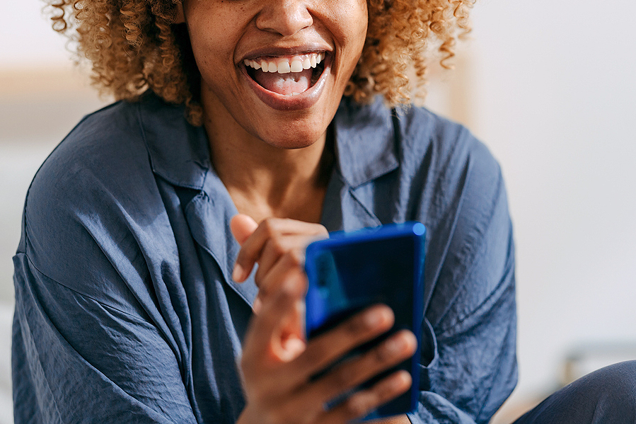 An image of a woman laughing at her phone
