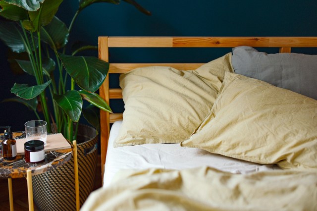 An image of a bed with white and tan sheets
