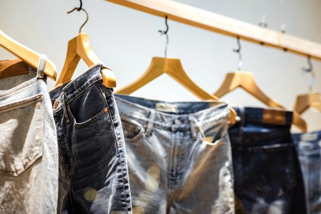 An image of several pairs of jeans hanging on a clothing rack