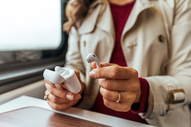 An image of a woman holding AirPods