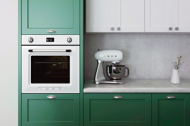 An image of a kitchen with green and white cabinets