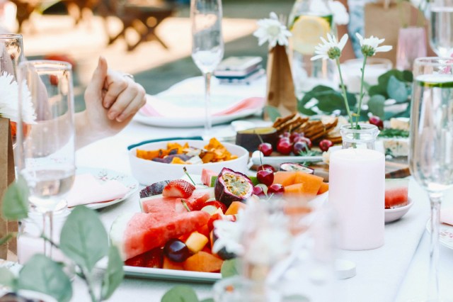 An image of food, flowers, and champagne glasses on an outdoor table