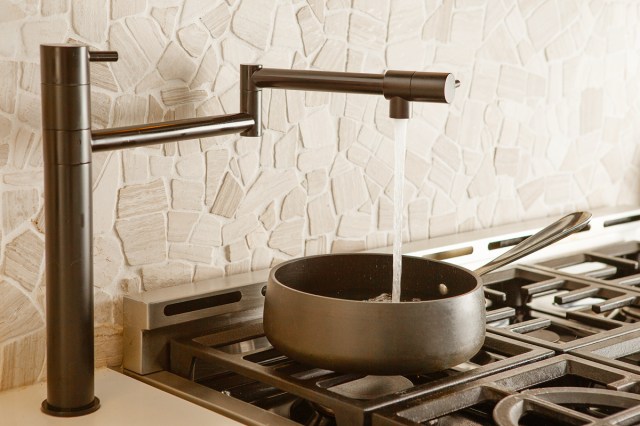 An image of a stovetop pot filler streaming water into a pot