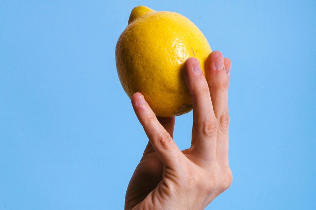 An image of a hand holding a lemon