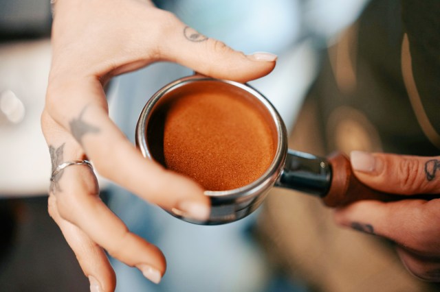 An image of a person holding an espresso portafilter 