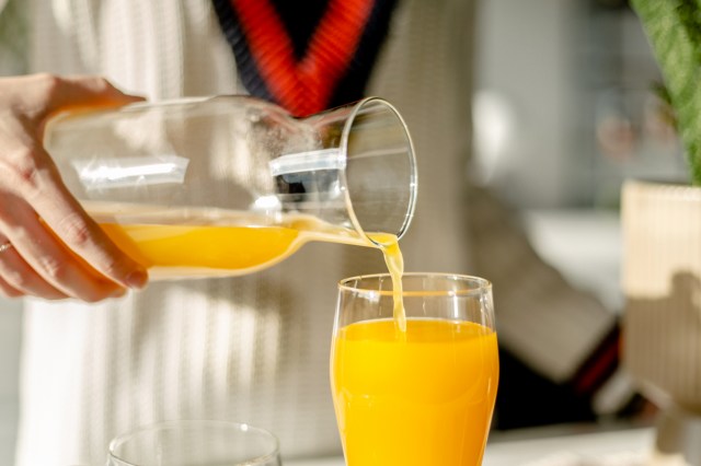 An image of a glass of orange juice being poured