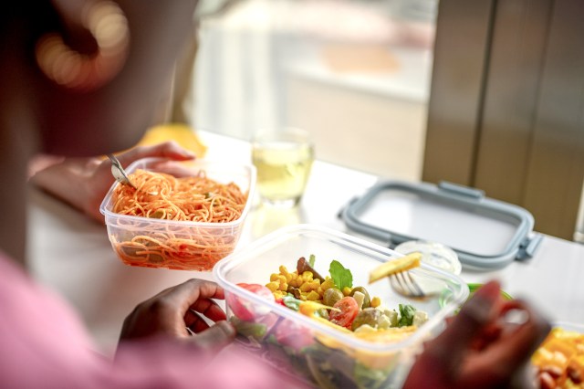 An image of a woman eating food out of a plastic container