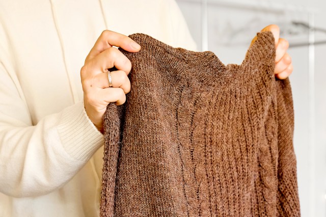 An image of a person holding a brown sweater