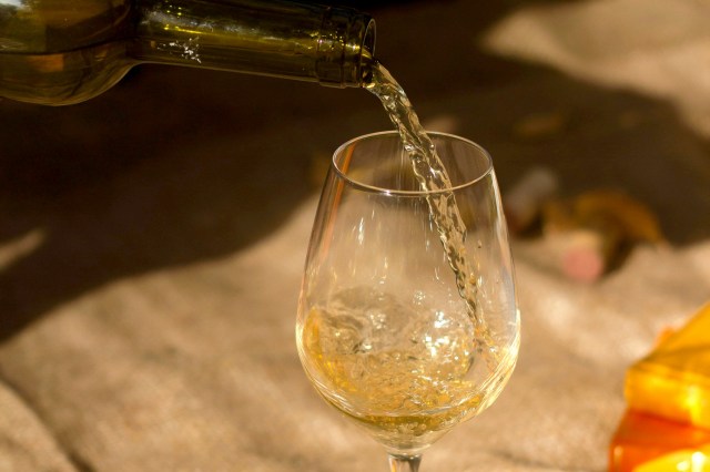 An image of a glass of white wine being poured