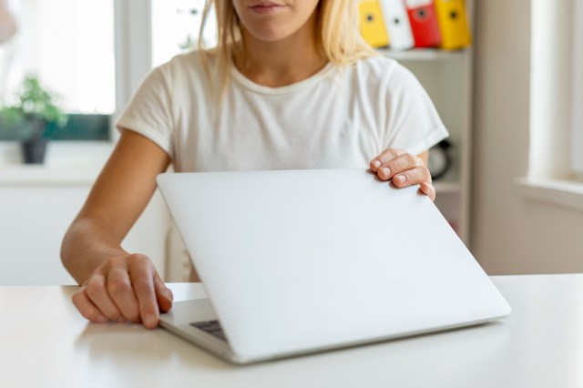 An image of a woman opening a laptop