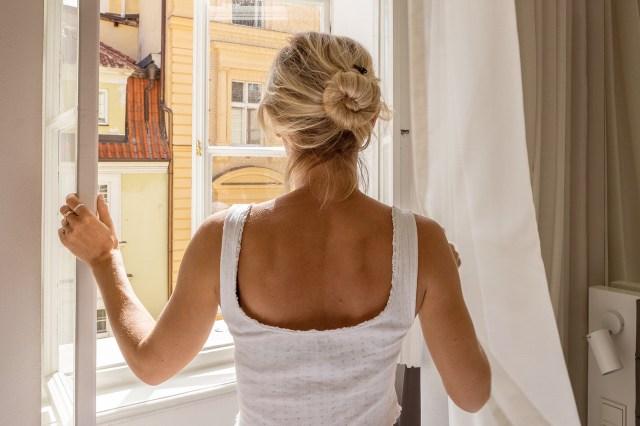An image of a woman looking out a window