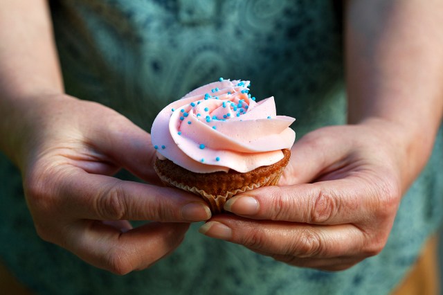 An image of a person holding a cupcake