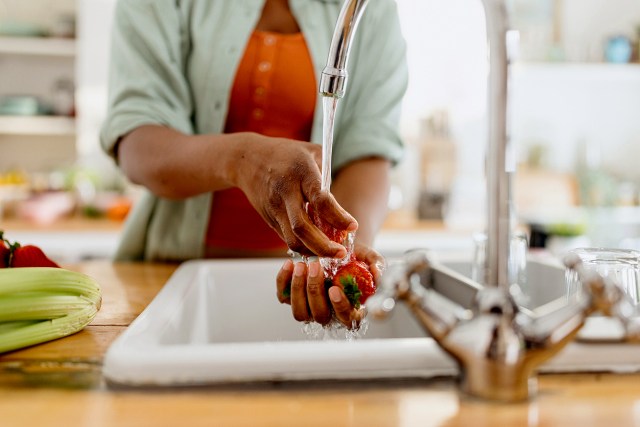 An image of a woman washing strawberries