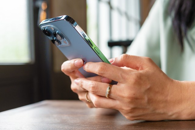 An image of a woman typing on her phone