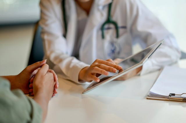 An image of a doctor showing a patient something on a tablet