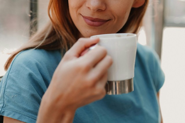 An image of a woman holding a white mug