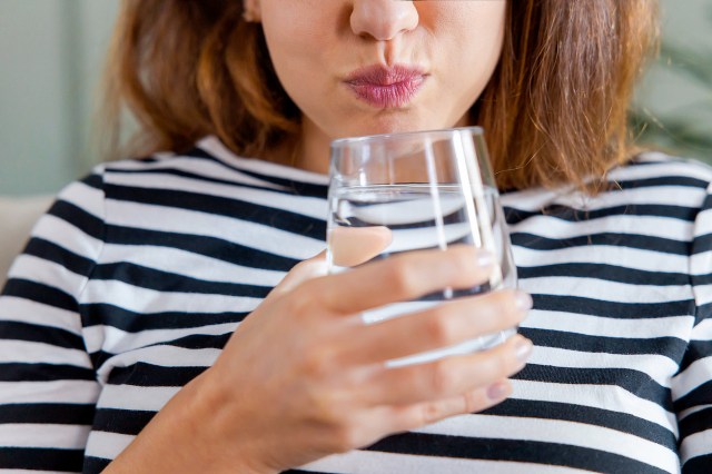 An image of a woman drinking a glass of water