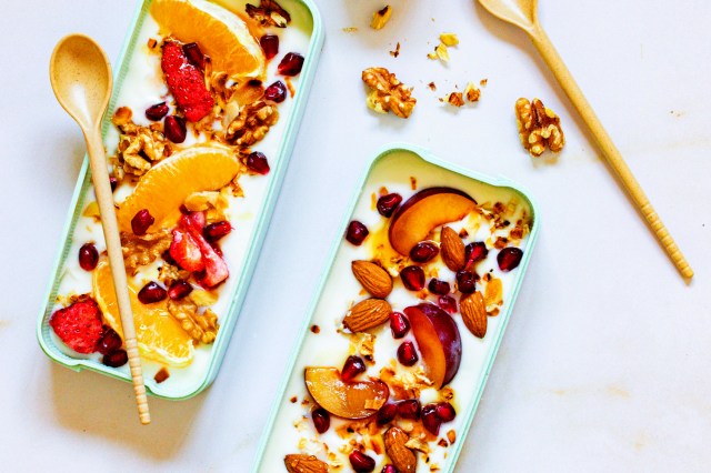 An image of two bowls of yogurt with fruit and nuts