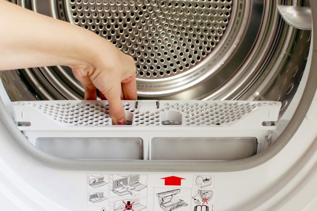 An image of a person pulling the lint trap out of a dryer