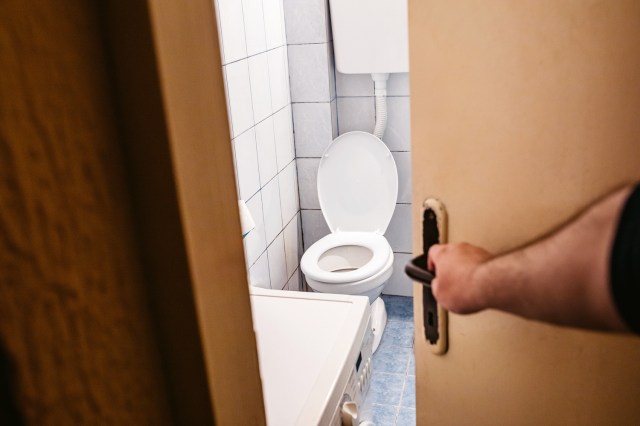 An image of a person opening a bathroom door