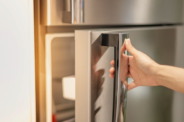 An image of a hand opening a refrigerator
