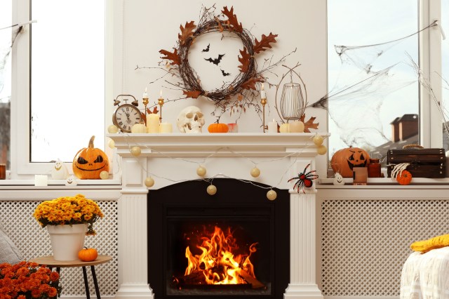 An image of a room with a fireplace decorated with autumn decorations