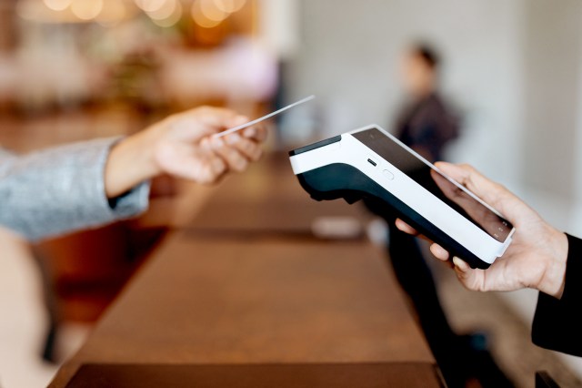 An image of a person tapping their credit card on a payment machine