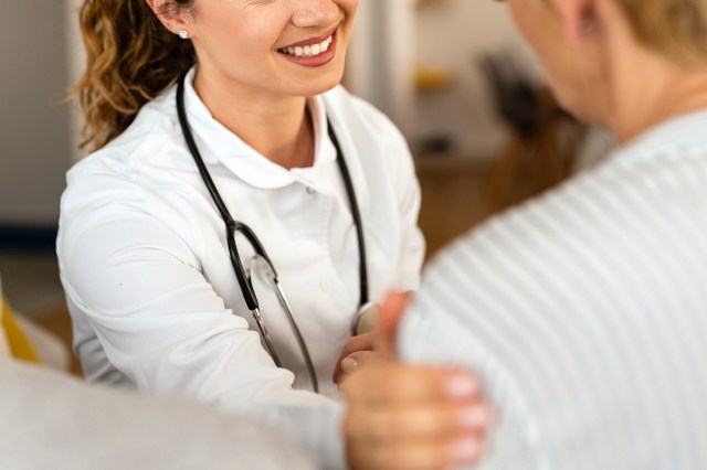 An image of a doctor touching a patient on the shoulder
