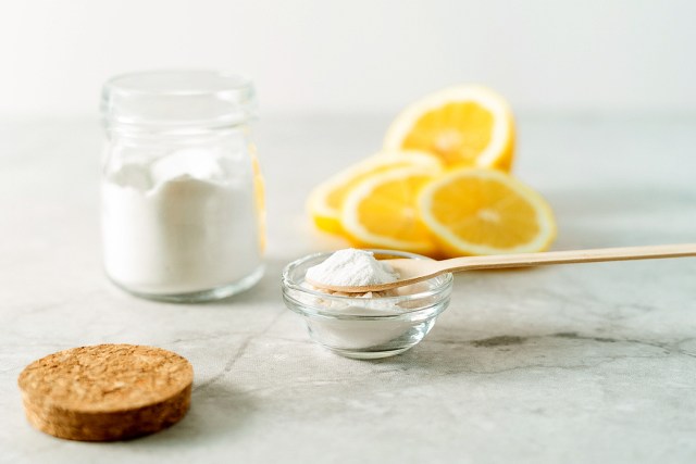 An image of a bowl of baking soda, a jar of salt, and lemon slices
